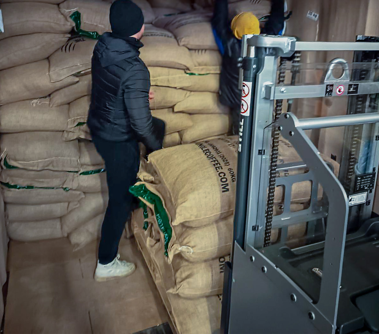 Warehouse team handling green coffee bags as part of Coffee supply chain
